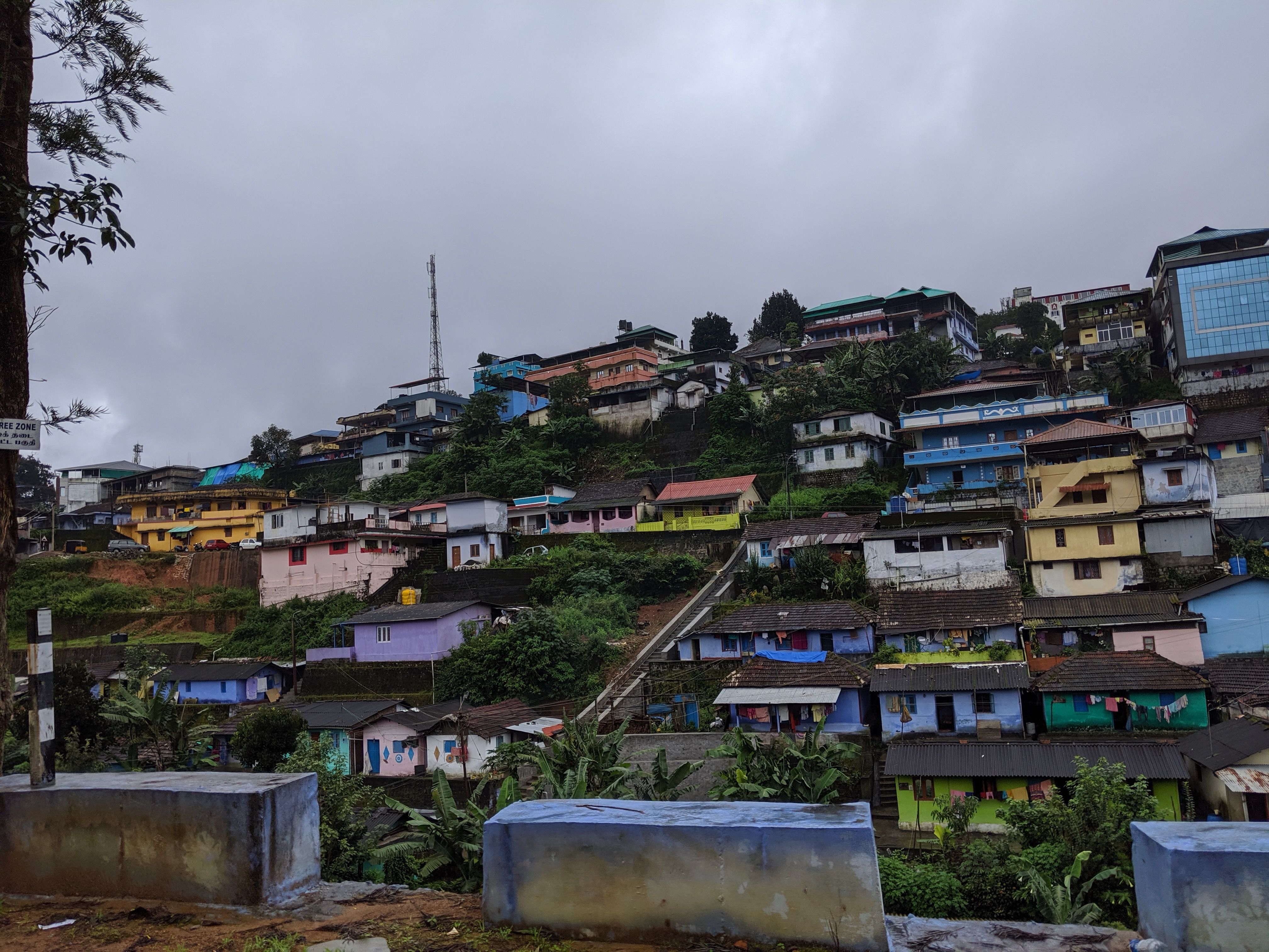Houses with a variety of colors placed on the slopes of a hill station